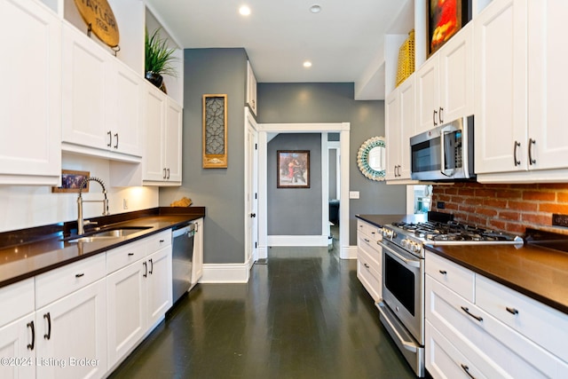 kitchen with appliances with stainless steel finishes, sink, and white cabinets