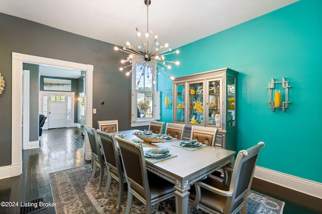 dining space with dark hardwood / wood-style floors and a chandelier