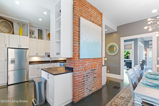 kitchen with stainless steel refrigerator with ice dispenser, dark wood-type flooring, sink, and white cabinets