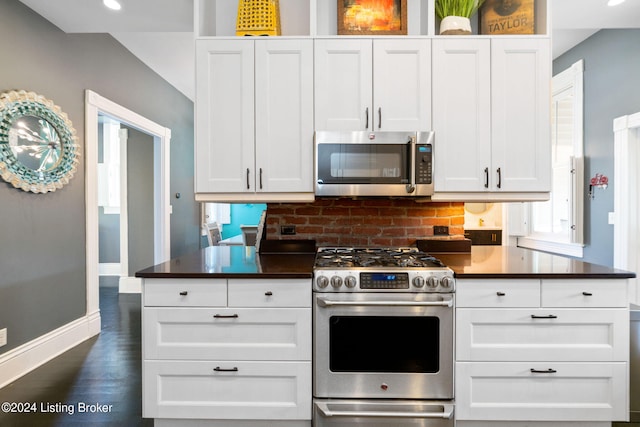 kitchen with white cabinetry, appliances with stainless steel finishes, dark wood-type flooring, and tasteful backsplash