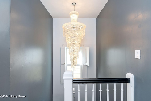 stairs featuring a chandelier