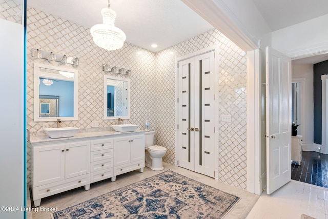 bathroom with vanity, toilet, tile patterned flooring, and tile walls