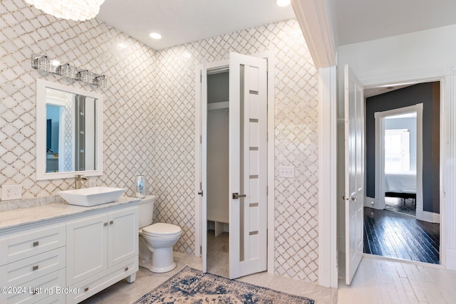 bathroom with hardwood / wood-style flooring, vanity, and toilet