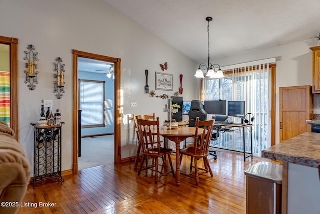 dining area with lofted ceiling, hardwood / wood-style floors, and a wealth of natural light