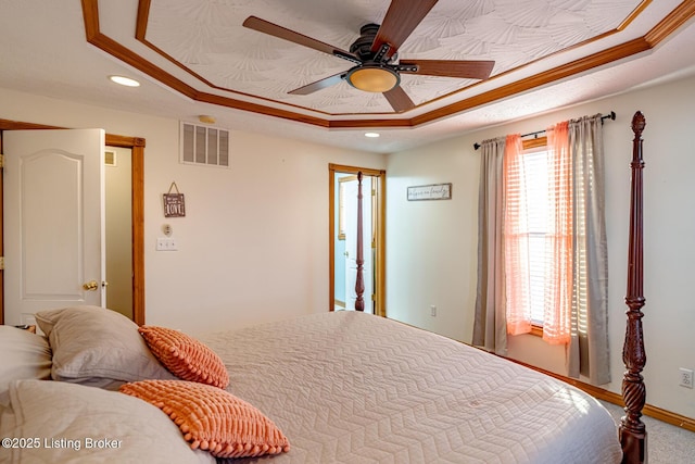 bedroom with crown molding and a tray ceiling