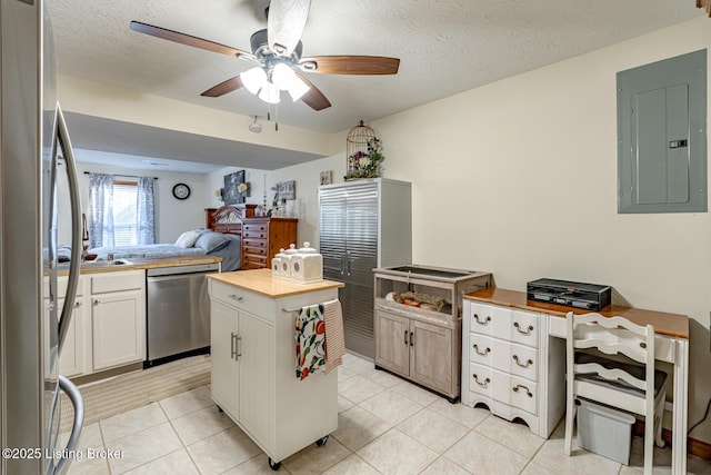 kitchen with white cabinetry, electric panel, wooden counters, and appliances with stainless steel finishes