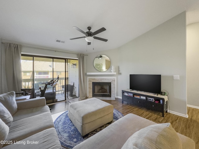 living room with hardwood / wood-style flooring, ceiling fan, and a fireplace