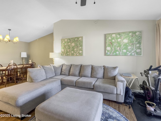 living room featuring lofted ceiling, a notable chandelier, and wood-type flooring