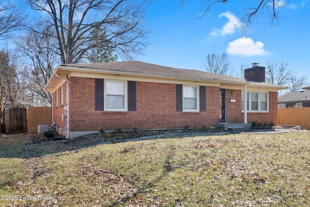 ranch-style home featuring cooling unit and a front yard