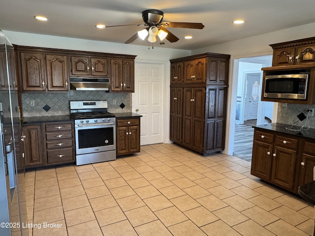 kitchen featuring light tile patterned flooring, dark brown cabinetry, appliances with stainless steel finishes, ceiling fan, and backsplash