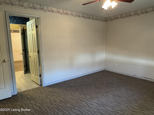 carpeted spare room with ceiling fan