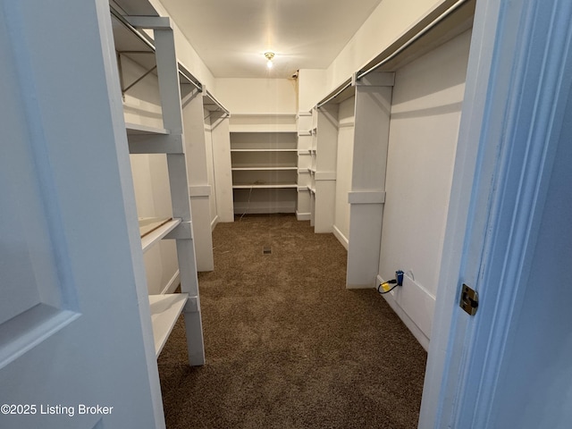 spacious closet featuring dark carpet