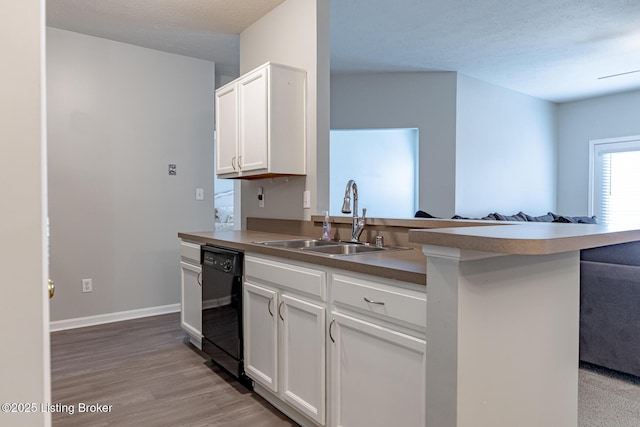 kitchen with sink, white cabinetry, light hardwood / wood-style flooring, dishwasher, and kitchen peninsula