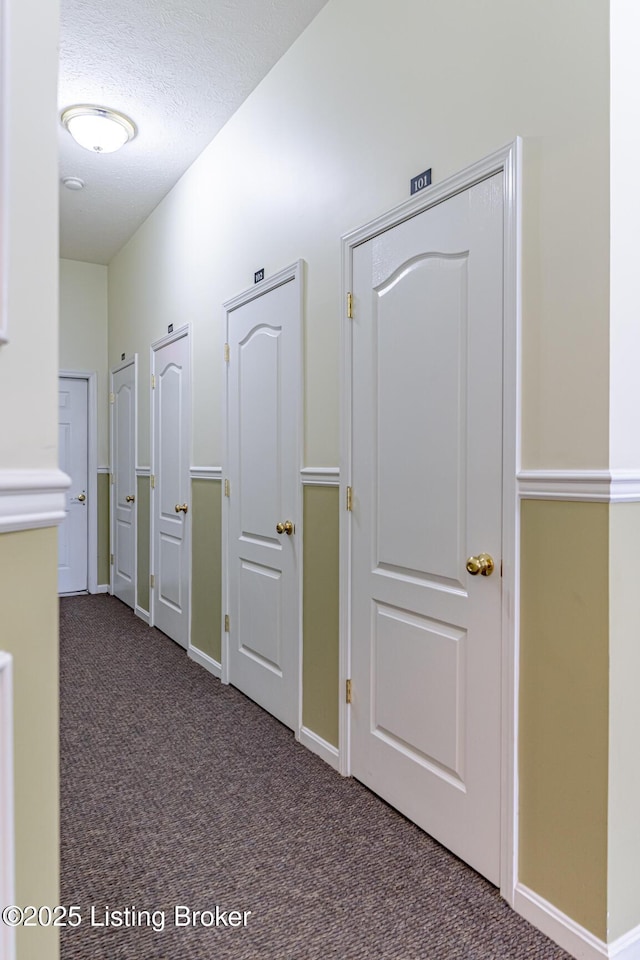 hallway featuring carpet floors and a textured ceiling