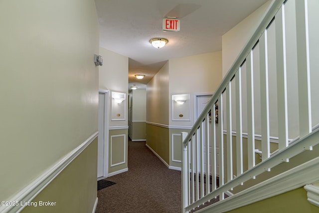 hallway with dark colored carpet