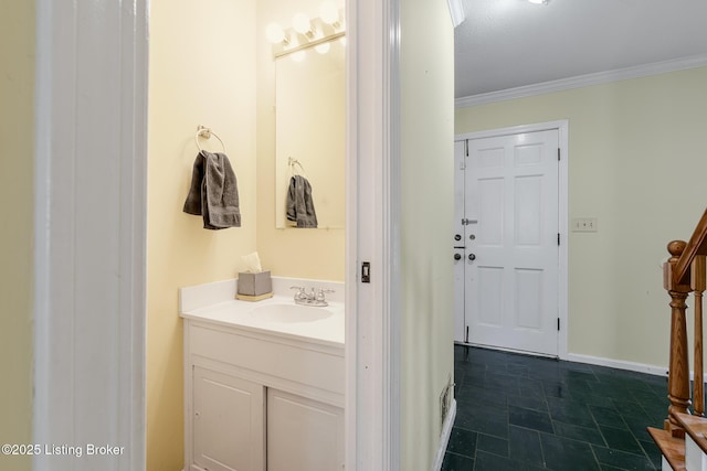 bathroom with baseboards, crown molding, and vanity