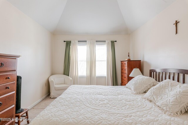 bedroom featuring lofted ceiling, light colored carpet, and baseboards