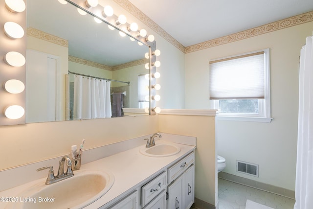 full bath with visible vents, a sink, toilet, and double vanity