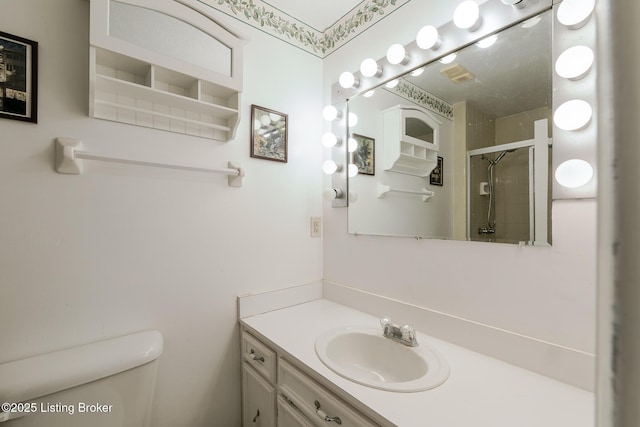 full bathroom with toilet, a stall shower, and vanity