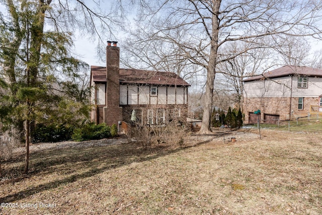 rear view of property featuring a chimney and stucco siding