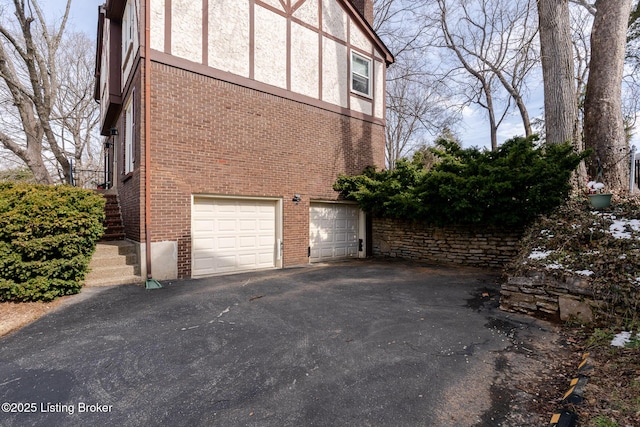 view of home's exterior with driveway, stairs, a garage, and brick siding