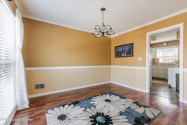 interior space with dark wood-style flooring, visible vents, crown molding, and an inviting chandelier