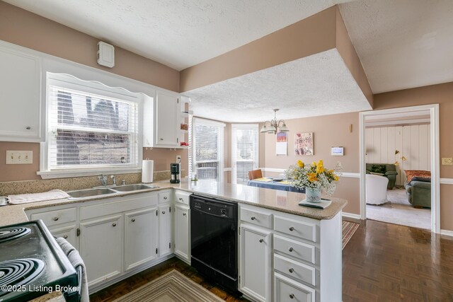 kitchen with light countertops, white cabinetry, a sink, dishwasher, and a peninsula