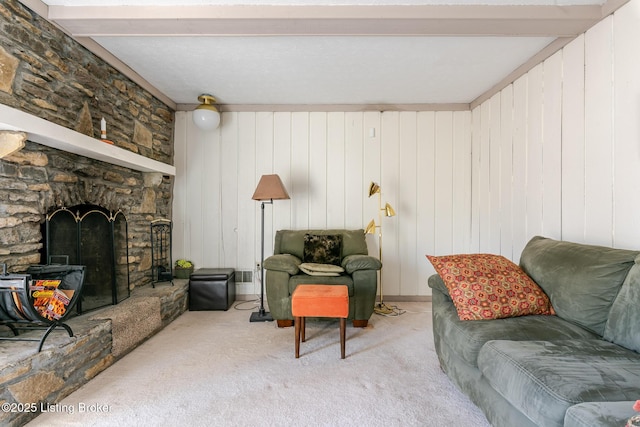 carpeted living area featuring a fireplace and beamed ceiling