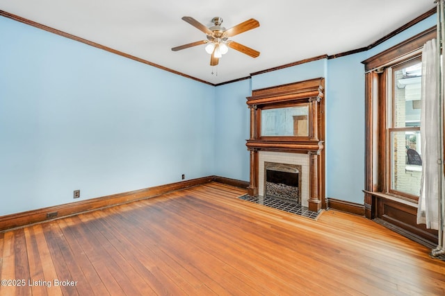 unfurnished living room with baseboards, a fireplace with flush hearth, crown molding, and hardwood / wood-style flooring