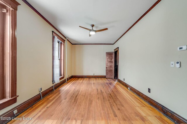 spare room featuring crown molding, a ceiling fan, baseboards, and light wood-type flooring