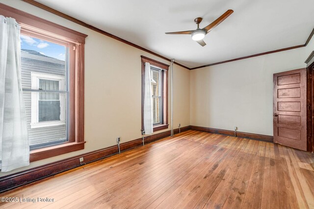 spare room featuring a wealth of natural light, ornamental molding, and light wood finished floors