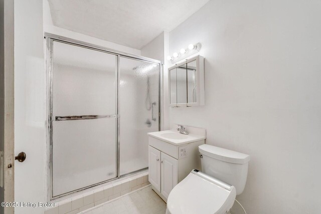 full bath featuring a stall shower, toilet, and vanity