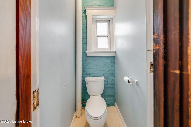 bathroom with toilet and baseboards