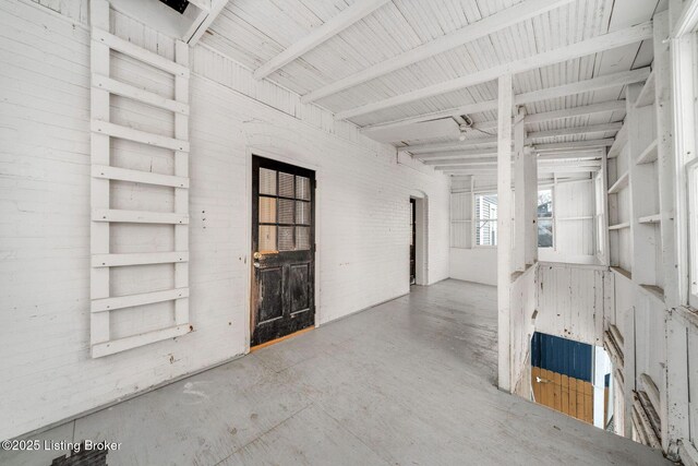 interior space featuring a ceiling fan and brick wall