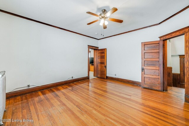 unfurnished bedroom featuring baseboards, wood-type flooring, a ceiling fan, and crown molding