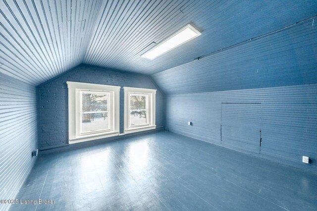 bonus room featuring wood finished floors and vaulted ceiling