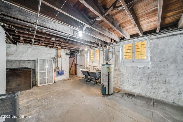 basement featuring water heater and a sink