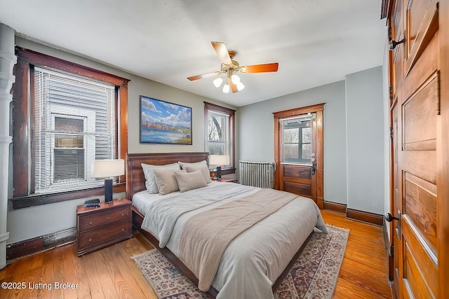 bedroom with light wood-style flooring, baseboards, and ceiling fan