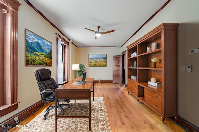 office space featuring crown molding, a ceiling fan, light wood-type flooring, and baseboards