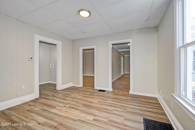 unfurnished room with light hardwood / wood-style flooring and a drop ceiling