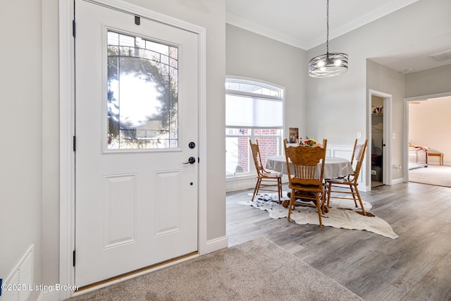 entrance foyer featuring crown molding and light hardwood / wood-style flooring