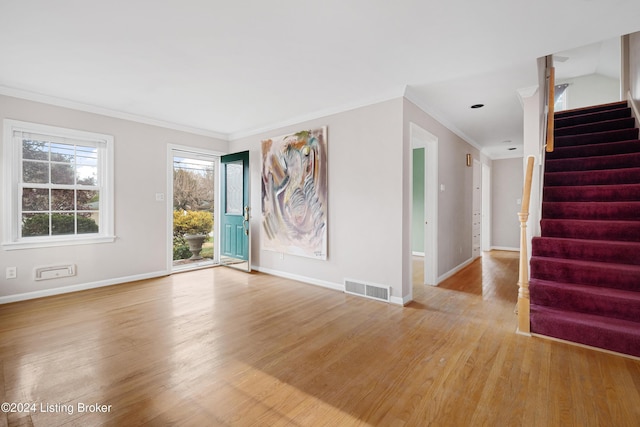 empty room with crown molding and light wood-type flooring