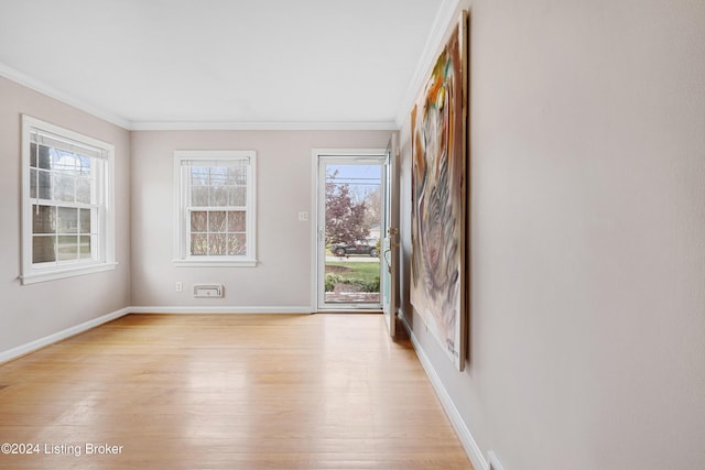 unfurnished room featuring ornamental molding and light hardwood / wood-style floors