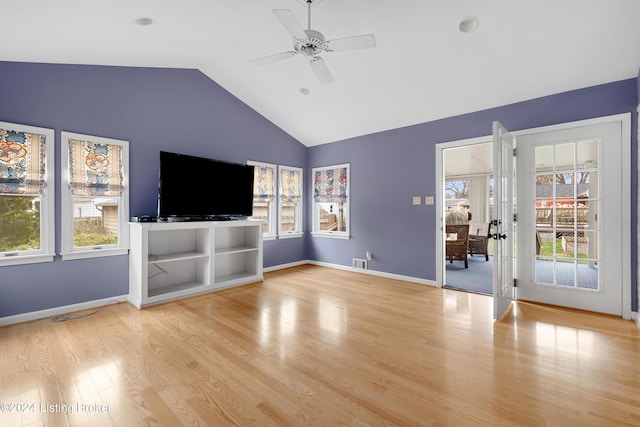 unfurnished living room with lofted ceiling, ceiling fan, a healthy amount of sunlight, and light wood-type flooring