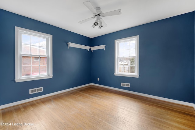 spare room with ceiling fan, plenty of natural light, and light hardwood / wood-style flooring