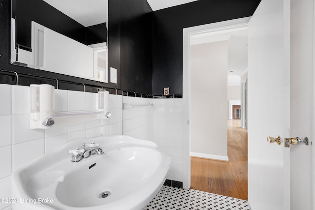 bathroom with sink and tile walls