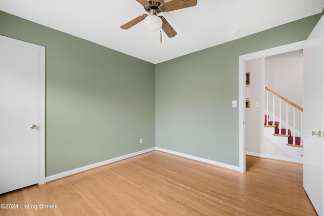 empty room with hardwood / wood-style flooring and ceiling fan