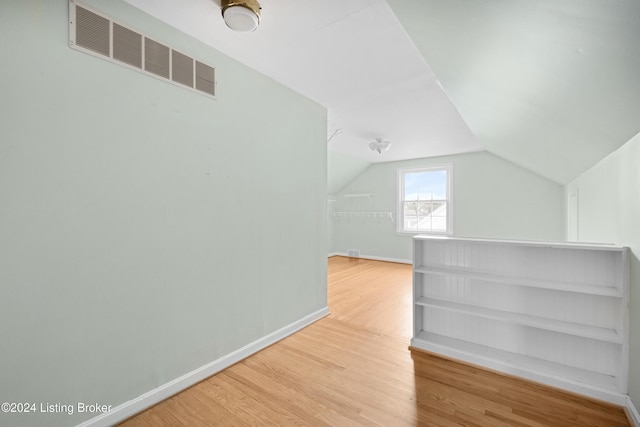 additional living space featuring hardwood / wood-style flooring and vaulted ceiling