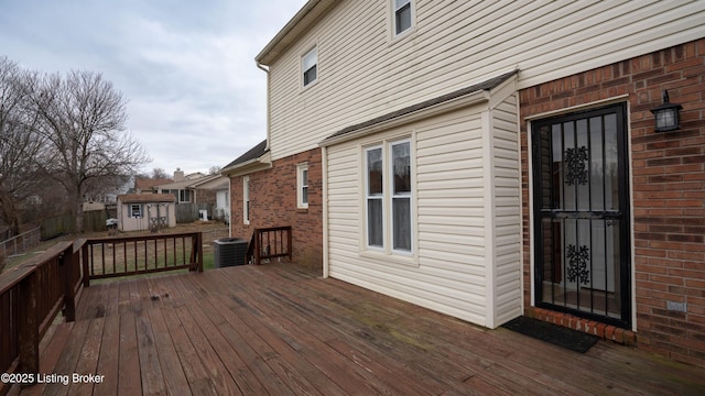 wooden terrace with a storage shed and central AC unit