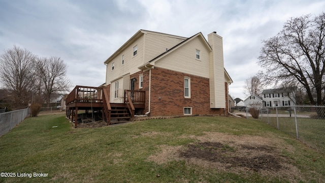 back of property with a yard and a deck